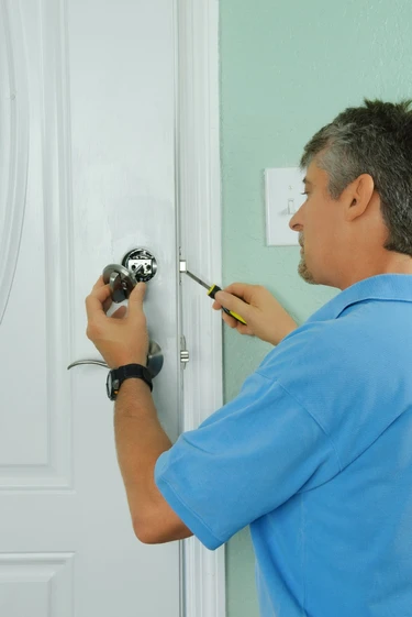 Residential Locksmith Lighthouse Point technician installing a deadbolt on a home door